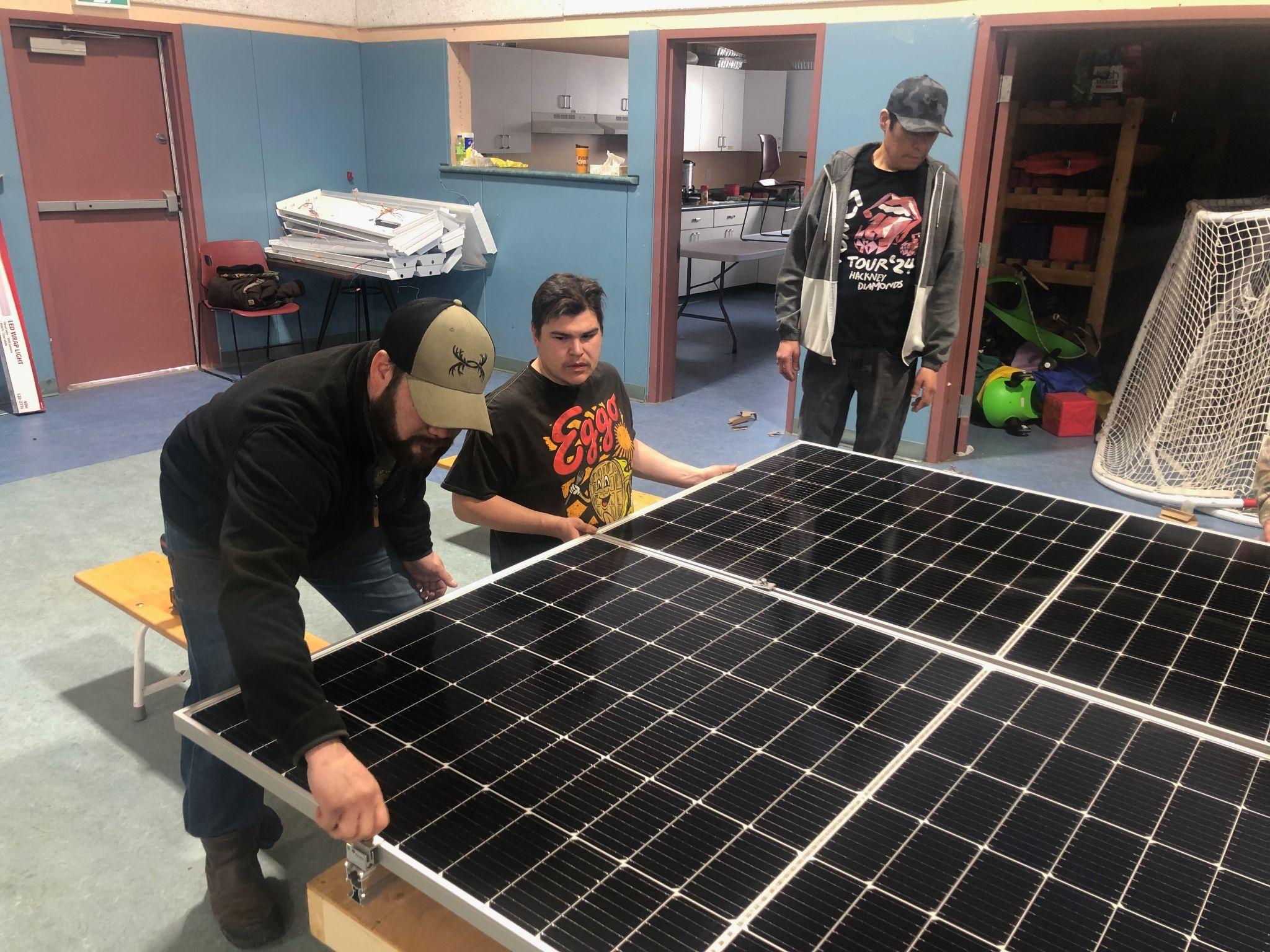 Community members inspecting a solar panel during hands-on training